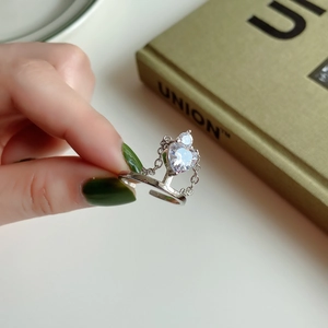 Close-up of a 925 sterling silver heart-shaped zircon ring with tassel chain details