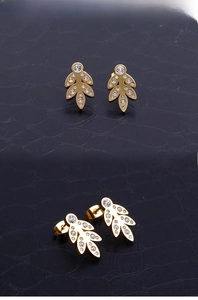 Detail of leaf stud earrings with gold plating and sparkling zircon crystal inlay