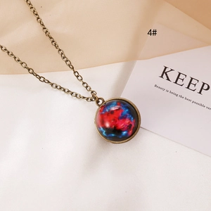Macro shot of bronze vintage celestial necklace with nebula pattern on cream fabric