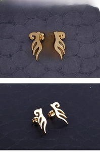 Detail view of gold hollow flame earrings on black texture, front and side profile shots