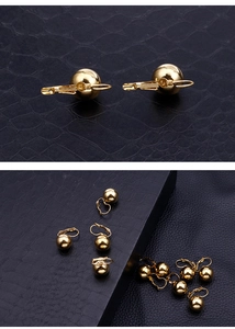 Close-up of elegant gold ball hook earrings on a textured black leather background