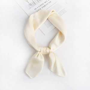 Detail of cream silk scarf with soft satin texture and elegant central knot