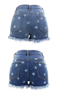 Detailansicht der blauen Jeans-Shorts mit weißen Sternenprints und ausgefranstem Saum