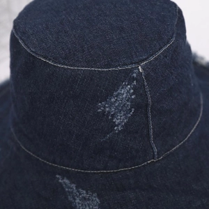 Detailed close-up of dark blue denim bucket hat showing vintage distressed fabric texture