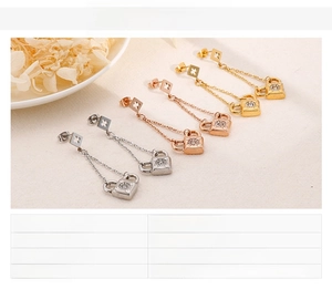 Detail view of long tassel lock earrings in gold and rose gold stainless steel