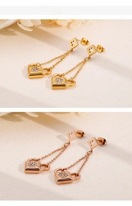 Detail of lock tassel drop earrings in gold and rose gold with zircon accents