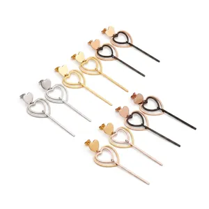 Détail macro de longues boucles d'oreilles cœur en acier inoxydable et leur texture
