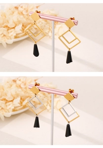 Detail of geometric titanium earrings with square frames and black trapezoid pendants
