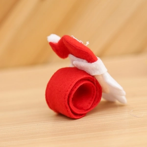 Red Christmas felt slap bracelet with Santa Claus design on a wooden background