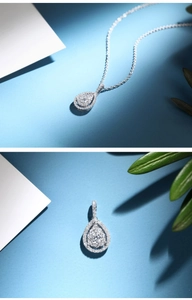 Détail macro du pendentif goutte en zircone avec halo de diamants sur chaîne argent