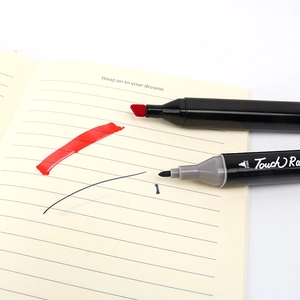 Dual-tip art markers showing broad chisel and fine points on a notebook page