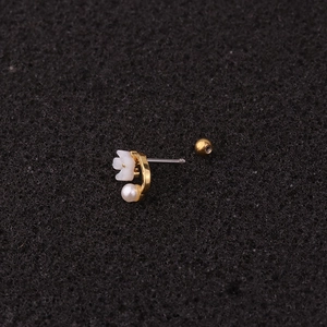 Macro view of golden flower stud earring with pearl pendant and screw back closure