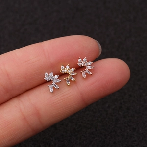 Macro view of three curved zircon stud earrings in silver, gold, and rose gold finishes