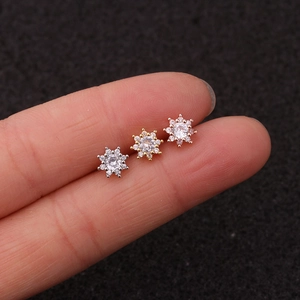 Macro shot of three star-shaped cartilage earrings in silver, gold, and rose gold finish
