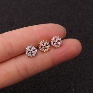 Macro detail of three zircon flower stud earrings in silver, gold, and rose gold finishes