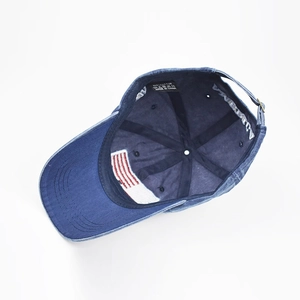 Dettaglio del cappellino da baseball in denim lavato con ricamo bandiera USA e fascia