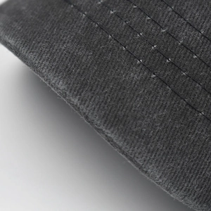Dettaglio ravvicinato della visiera in cotone grigio con cuciture parallele del cappello