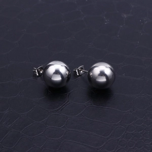 Polished silver stainless steel ball stud earrings on black crocodile texture background