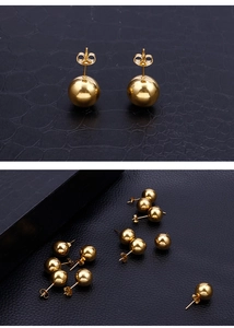 Detailed close-up of 18k gold-plated stainless steel ball stud earrings on black texture