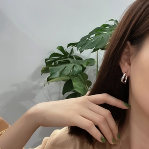 Minimalist 925 sterling silver geometric hoop earrings worn by a model in casual style