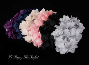 Detailed view of multi-color floral bag accessories with fabric petals and center rhinestones