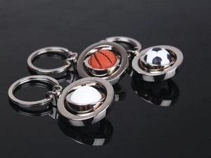 Detail of silver metal sports keychains with basketball, football, and golf ball pendants