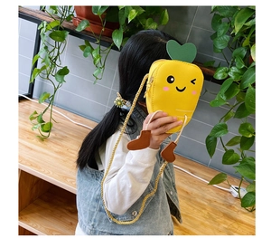 Detailed back view of a cute carrot-shaped yellow crossbody bag worn by a child
