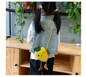 Close-up of cute carrot crossbody bag for kids with cartoon face and leaf detail