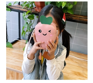 Detailed view of child wearing cute pink carrot-shaped crossbody bag with soft strap