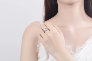 Close-up of elegant heart-shaped zircon ring on hand with silver setting and small stones