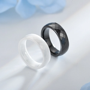 Detail of faceted black and white ceramic rings showing precise diamond-cut texture