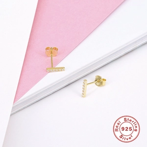 Detailed shot of golden S925 sterling silver bar earrings with inlaid diamonds