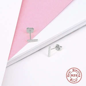 Macro view of S925 sterling silver bar earrings with inlaid diamonds and seal