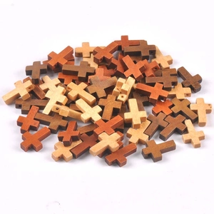 Detailed close-up of mixed wood cross beads with side holes for DIY jewelry making