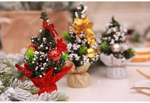 Detailed close-up of mini Christmas trees with faux snow, bows and ornaments in festive colors