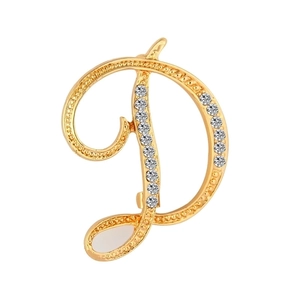 Close-up of golden letter D brooch with sparkling crystals and beaded edge detail