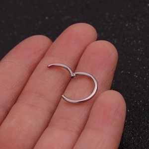 Silver stainless steel hinged segment ring shown on finger for scale and size reference