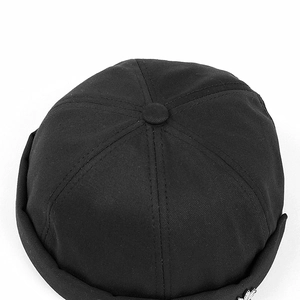 Detail of black cotton docker hat featuring a silver star metal badge and 6-panel design