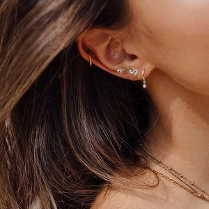 Elegant gold pearl earrings set with cubic zirconia stones shown on ear for women