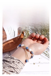 Detailed view of blue aventurine stone beads and freshwater pearl bracelet on a wrist