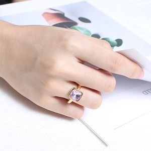 Minimalist gold titanium steel ring with cushion-cut lilac zircon on lifestyle background