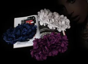 Detailed view of handmade fabric floral clusters on elegant satin evening clutch bags