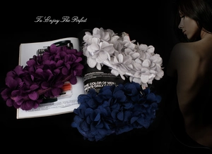 Detailed view of layered fabric floral accessories in purple, white and navy blue