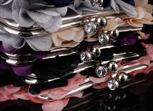 Macro view of multi-color chiffon petal clutches with rhinestone metal clasp details