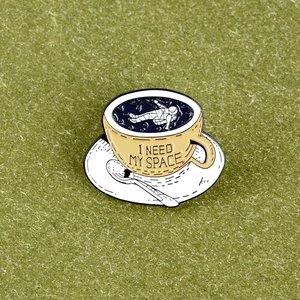 Detail view of enamel pin with astronaut in coffee cup and I NEED MY SPACE text