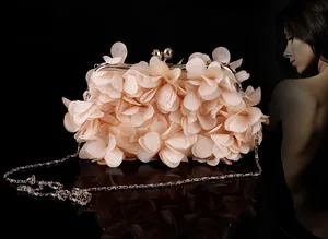 Close-up of 3D fabric petals on bridal clutch bag with golden frame and metal chain