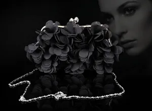 Detail of 3D floral petals on black evening clutch with crystal clasp and silver chain