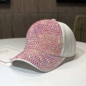 Dettaglio macro dei brillantini rosa scintillanti sulla visiera del cappello bianco in cotone