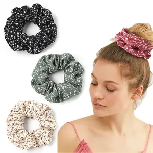 Detail view of floral print scrunchies set featuring a model wearing the dark red style