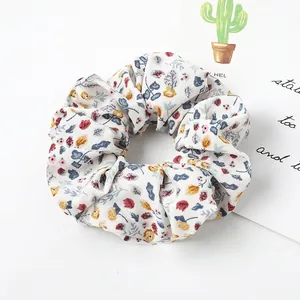 Macro detail of elastic fabric scrunchie featuring vintage floral pattern and soft texture
